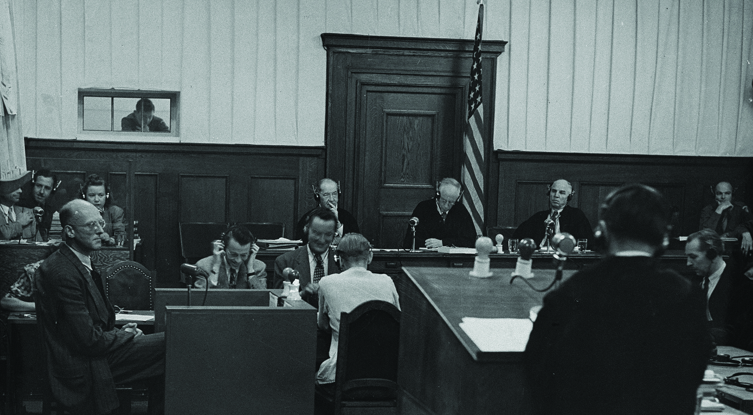 The judges in the IMT Justice case, including Justin W. Harding, sitting just right of the flag. Harding was a
        judge advocate colonel in WWII, but was a civilian at the time of the trial. (Photo courtesy of Fred Borch III)